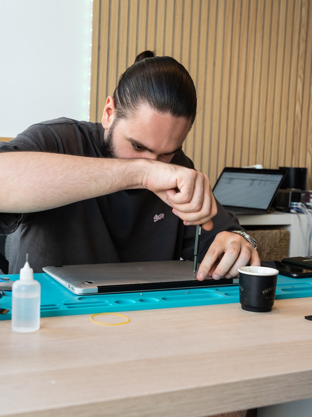 Technicien Repair Place en train de démonter un ordinateur portable pour réparation à Chamalières