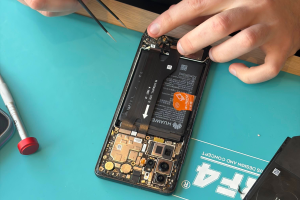 Smartphone ouvert avec sa batterie visible, remplacement de batterie à l'atelier de Chamalières